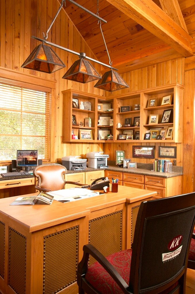 Imagen de despacho rústico con paredes marrones, escritorio independiente y suelo de madera en tonos medios