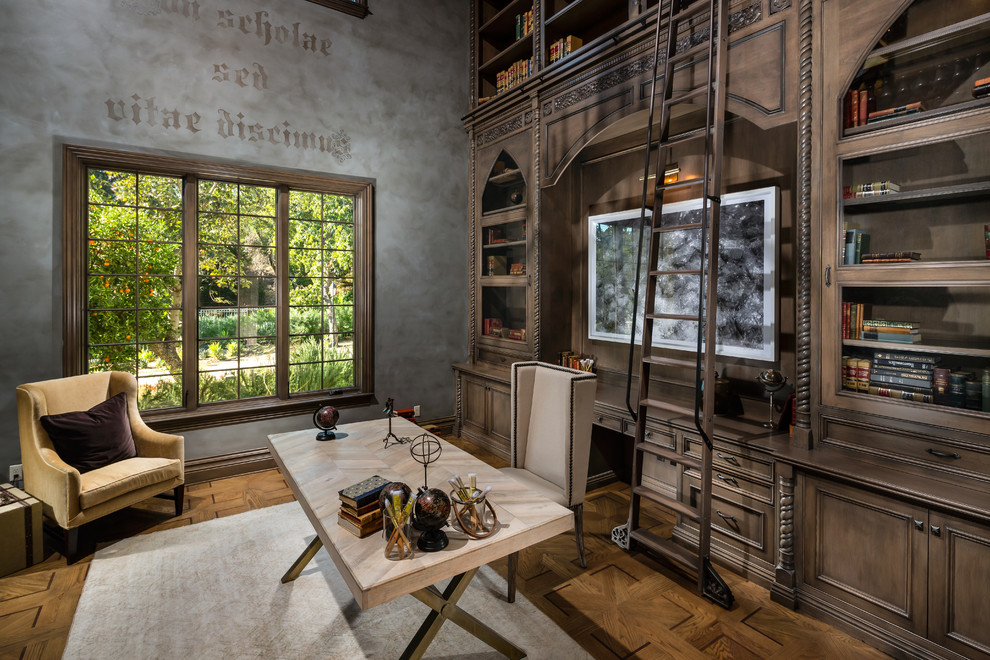 Imagen de despacho mediterráneo extra grande con biblioteca, paredes multicolor, suelo de madera oscura, escritorio independiente y suelo marrón