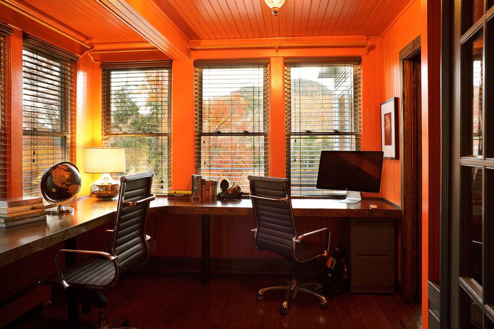 Aménagement d'un bureau contemporain avec un mur orange et parquet foncé.