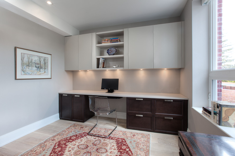 Ejemplo de despacho ecléctico de tamaño medio sin chimenea con paredes grises, suelo de madera clara y escritorio empotrado