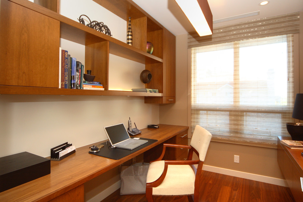 Esempio di un piccolo ufficio classico con pareti beige, pavimento in legno massello medio e scrivania incassata