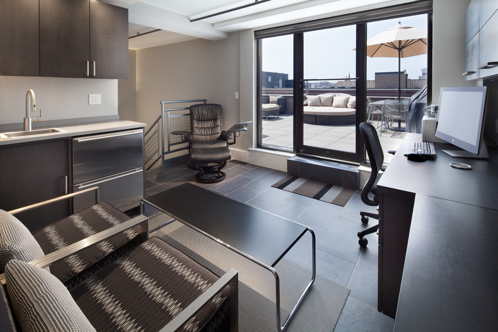 Пример оригинального дизайна: рабочее место среднего размера в современном стиле с серыми стенами, полом из сланца и встроенным рабочим столом без камина