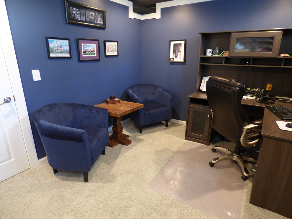 Réalisation d'un petit bureau champêtre avec un mur bleu, moquette, aucune cheminée et un bureau indépendant.