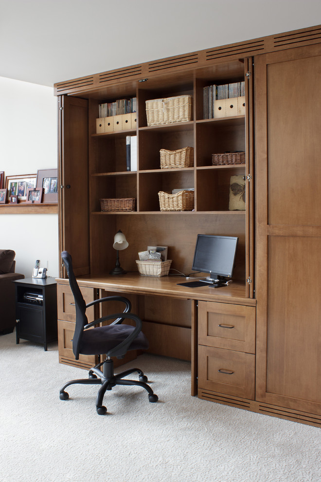 Modelo de despacho de estilo americano grande con paredes beige, moqueta y escritorio empotrado