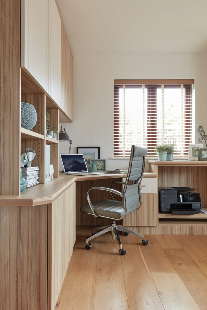 Foto på ett mellanstort funkis arbetsrum, med beige väggar, mellanmörkt trägolv, ett inbyggt skrivbord och brunt golv