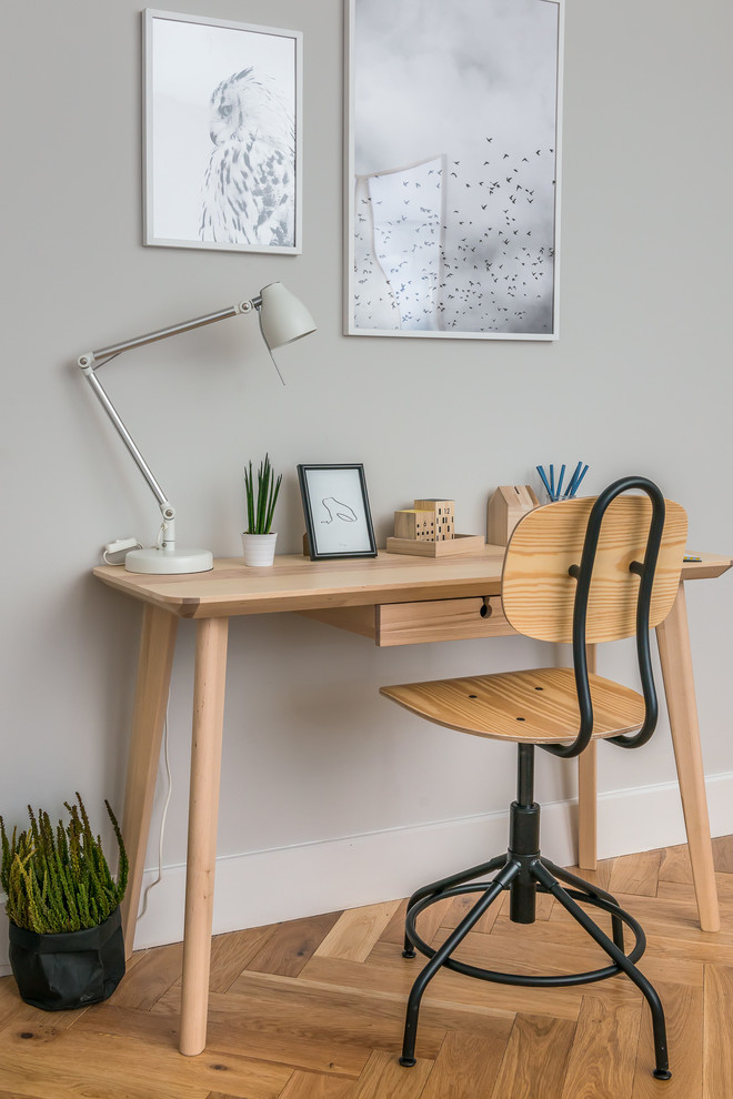Cette image montre un petit bureau nordique avec un mur gris et un bureau indépendant.