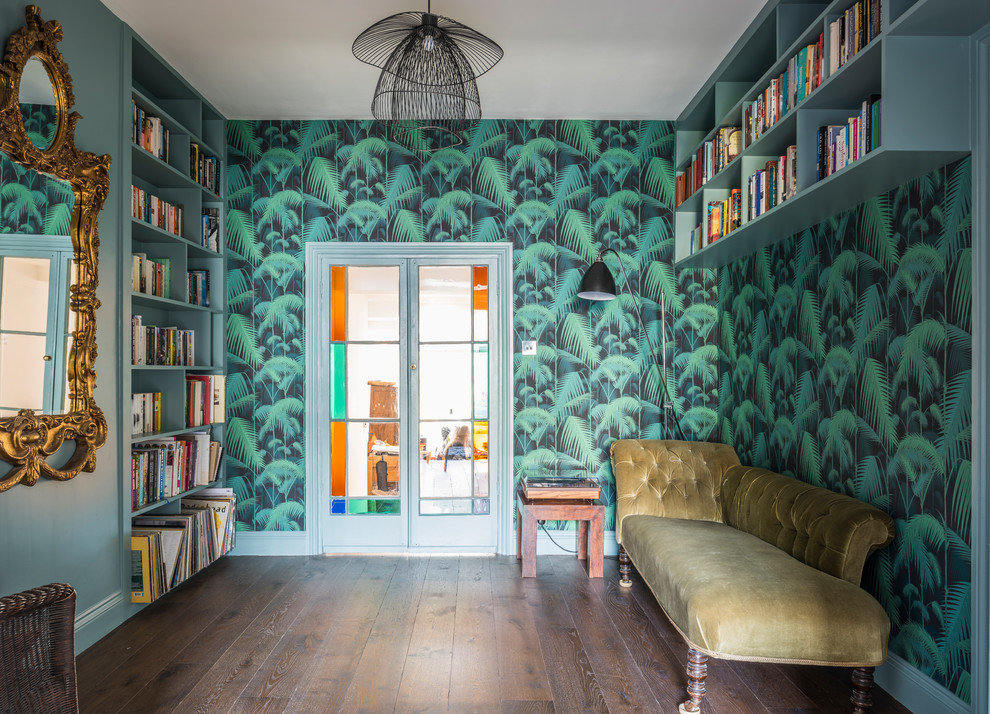 Inredning av ett eklektiskt mellanstort arbetsrum, med ett bibliotek, gröna väggar, mörkt trägolv och brunt golv