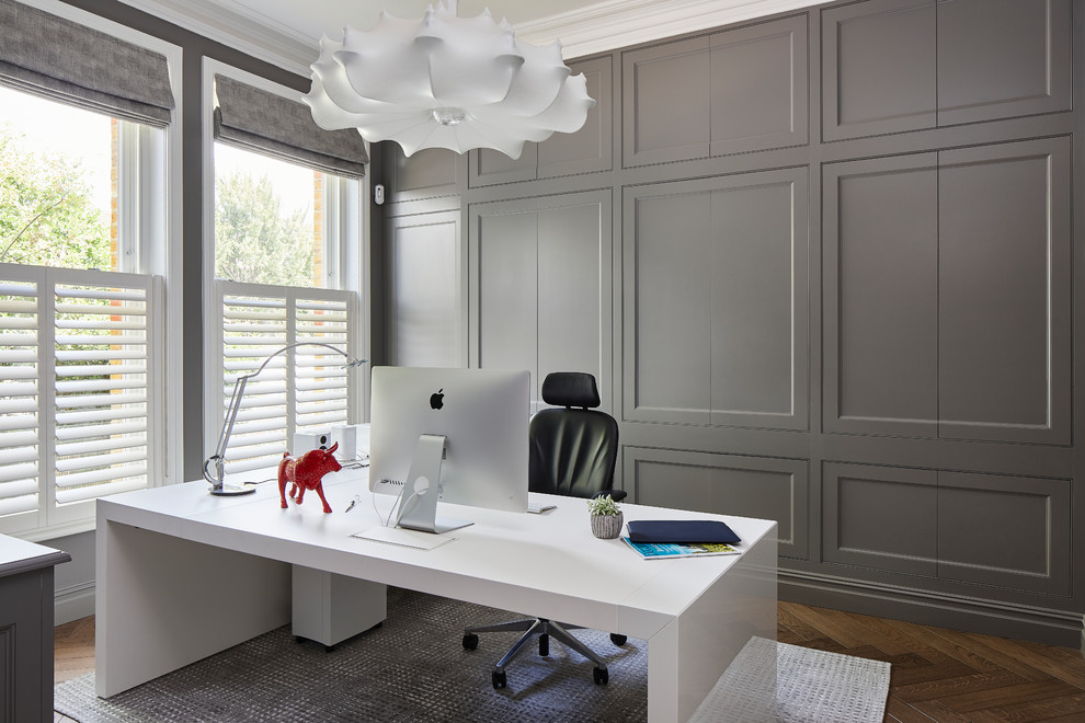 Ispirazione per un ampio ufficio tradizionale con pareti grigie, pavimento in legno massello medio, nessun camino, scrivania autoportante e pavimento marrone