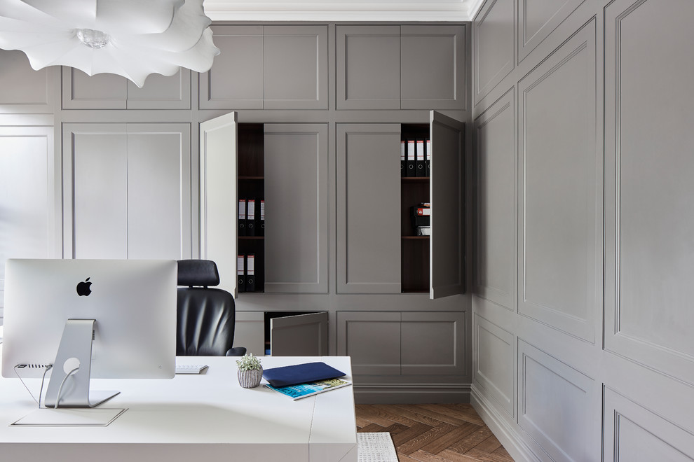 Esempio di un ufficio classico con pareti grigie, pavimento in legno massello medio, scrivania autoportante e pavimento marrone