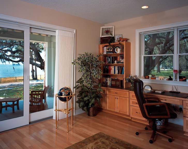 Imagen de despacho de estilo americano de tamaño medio con paredes beige, suelo de madera clara y escritorio empotrado
