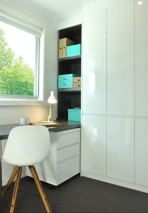 Idee per un grande ufficio minimalista con scrivania incassata, pareti bianche, moquette, nessun camino e pavimento marrone