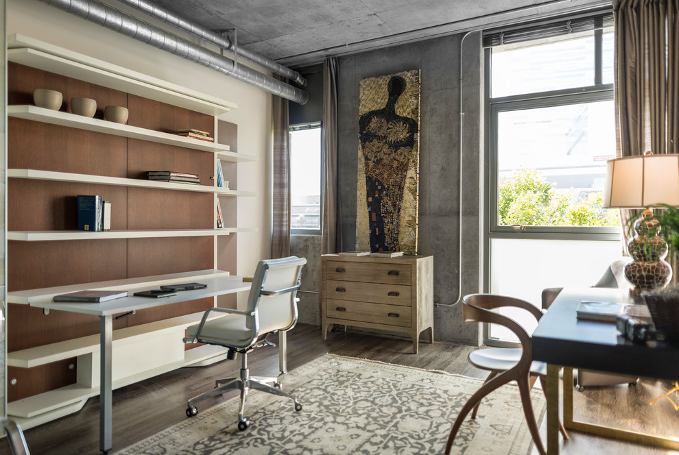 Mittelgroßes Industrial Arbeitszimmer ohne Kamin mit Arbeitsplatz, grauer Wandfarbe, dunklem Holzboden und Einbau-Schreibtisch in Los Angeles