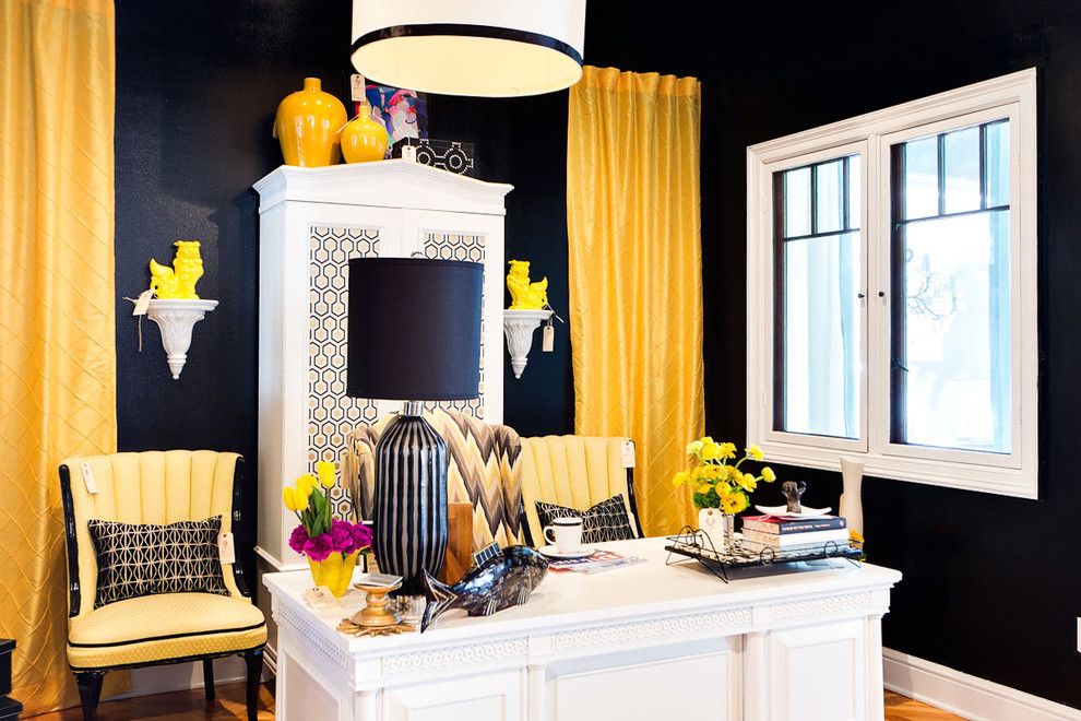 Trendy freestanding desk medium tone wood floor home office photo in Dallas with black walls