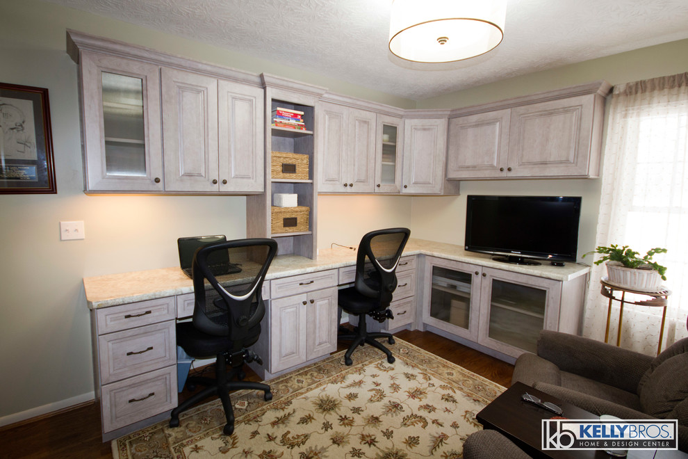 Modelo de despacho tradicional renovado de tamaño medio con paredes grises, suelo de madera en tonos medios y escritorio empotrado