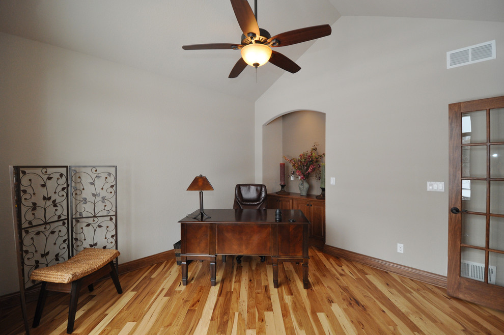Exemple d'un grand bureau chic avec un mur beige, un sol en bois brun et un bureau indépendant.