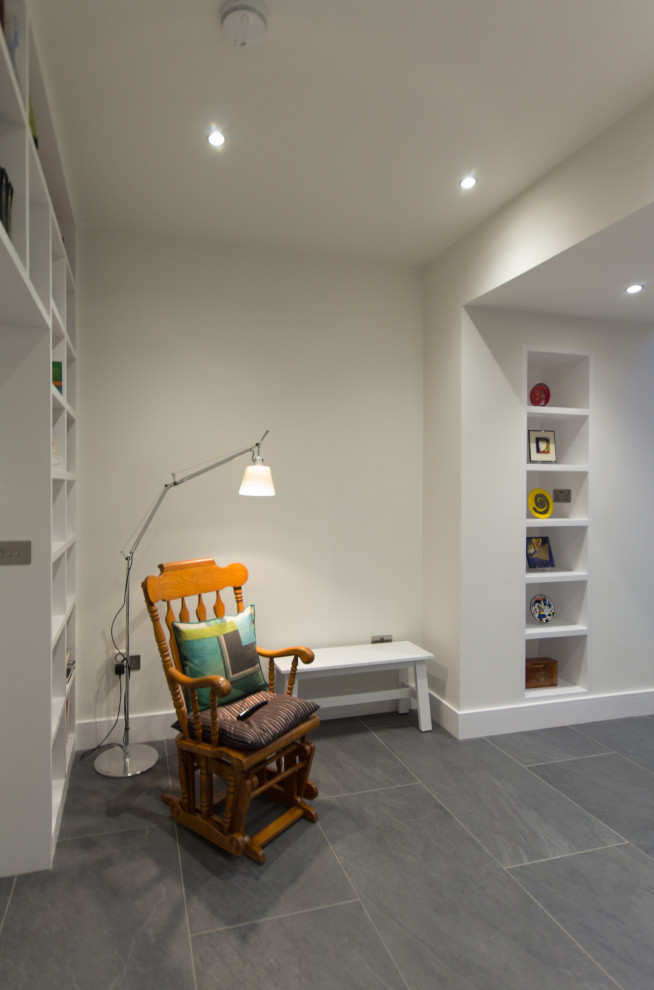ロンドンにあるお手頃価格の中くらいなコンテンポラリースタイルのおしゃれなホームオフィス・書斎 (ライブラリー、白い壁、テラコッタタイルの床、暖炉なし、マルチカラーの床) の写真