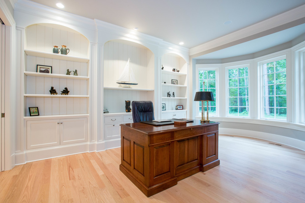 Traditional study in Other with grey walls, light hardwood flooring and a freestanding desk.