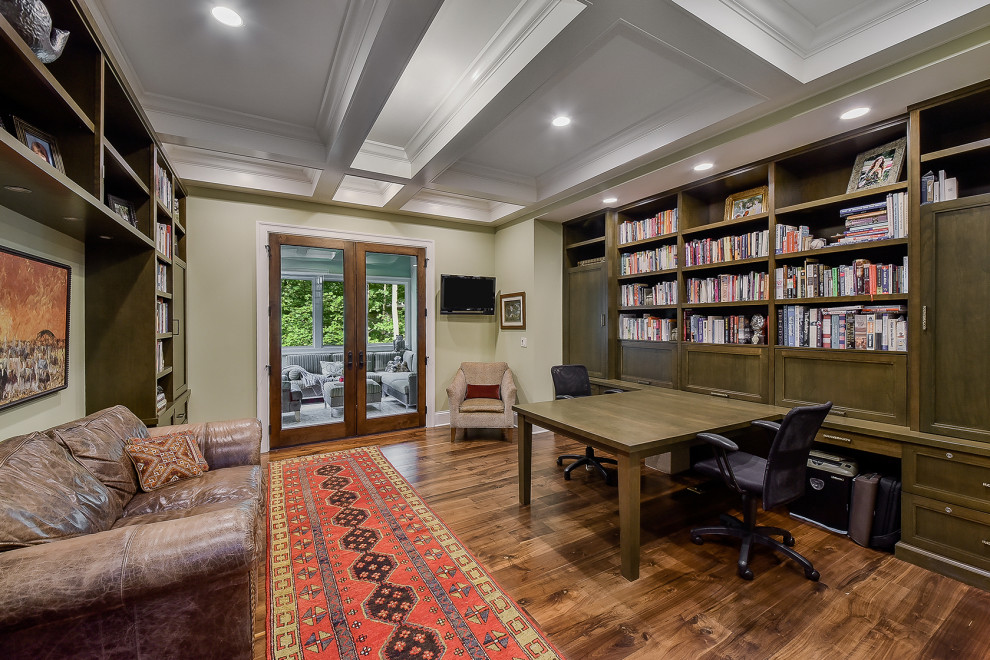 Inspiration för mellanstora arbetsrum, med ett bibliotek, beige väggar, mellanmörkt trägolv, ett inbyggt skrivbord och brunt golv