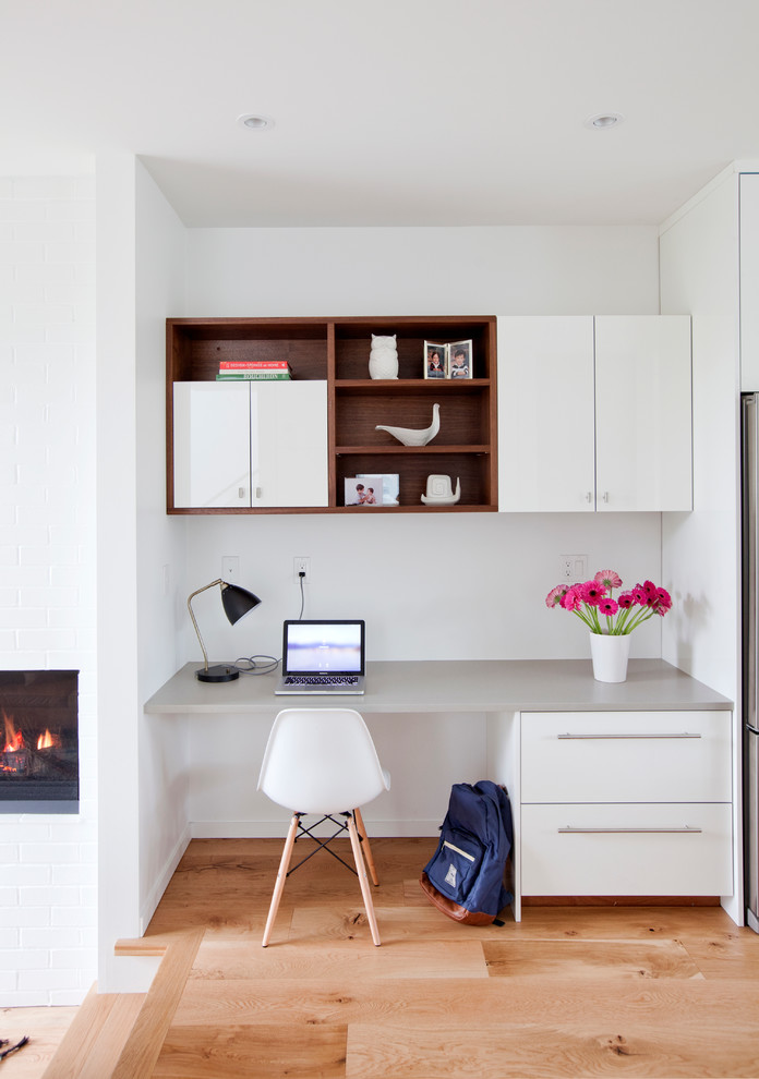 Idee per un ufficio minimal con pareti bianche, parquet chiaro e scrivania incassata
