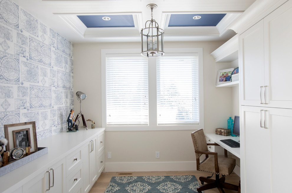 Home office - mid-sized transitional built-in desk light wood floor home office idea in Vancouver with white walls