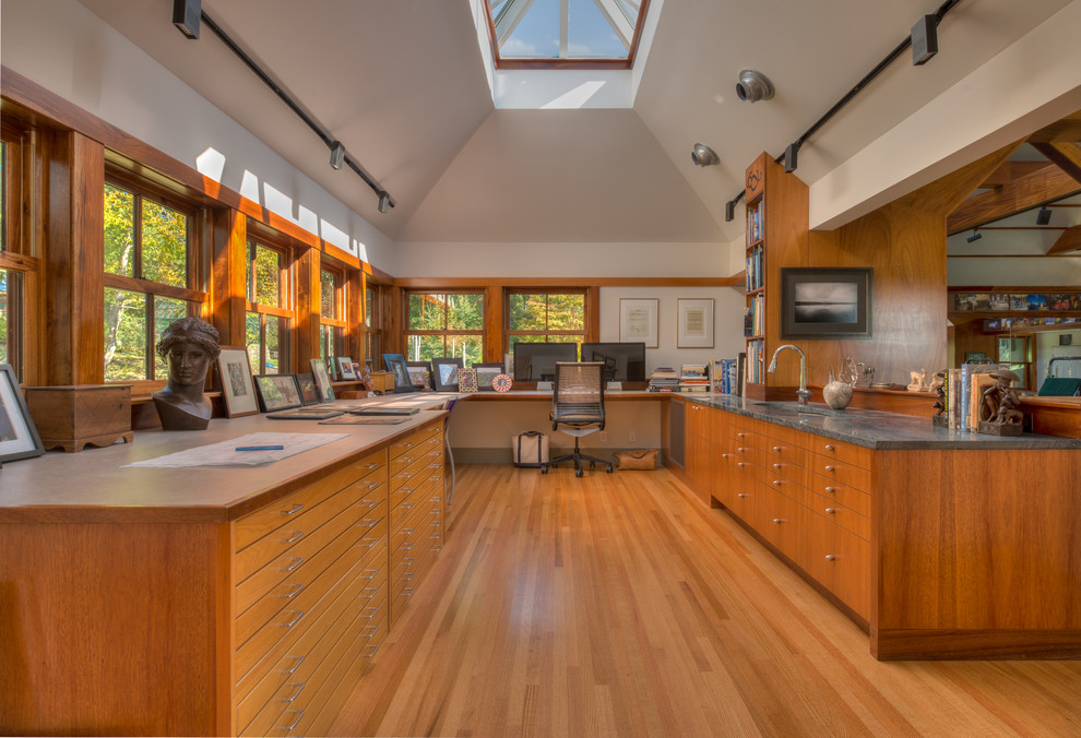Kleines Modernes Arbeitszimmer mit Studio, beiger Wandfarbe, braunem Holzboden und Einbau-Schreibtisch in Sonstige