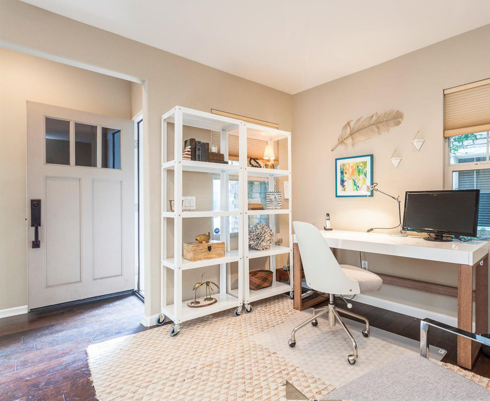 Idee per un piccolo ufficio eclettico con pareti bianche, pavimento in laminato, scrivania autoportante e pavimento marrone