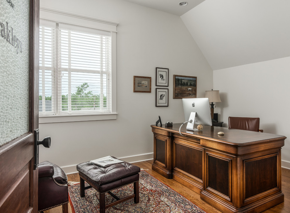 Esempio di uno studio stile americano con pareti bianche, pavimento in legno massello medio e scrivania autoportante