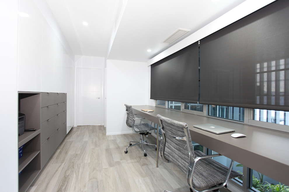 Esempio di un ufficio minimal di medie dimensioni con pareti bianche, pavimento in gres porcellanato, scrivania incassata e pavimento beige