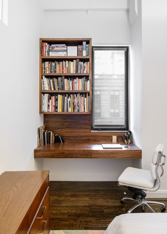 Small contemporary study in New York with white walls and a built-in desk.
