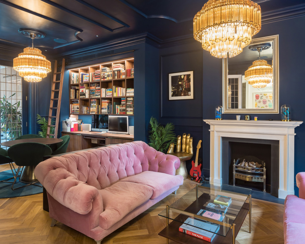 ロンドンにあるトランジショナルスタイルのおしゃれな書斎 (青い壁、無垢フローリング、標準型暖炉、造り付け机、茶色い床、パネル壁) の写真