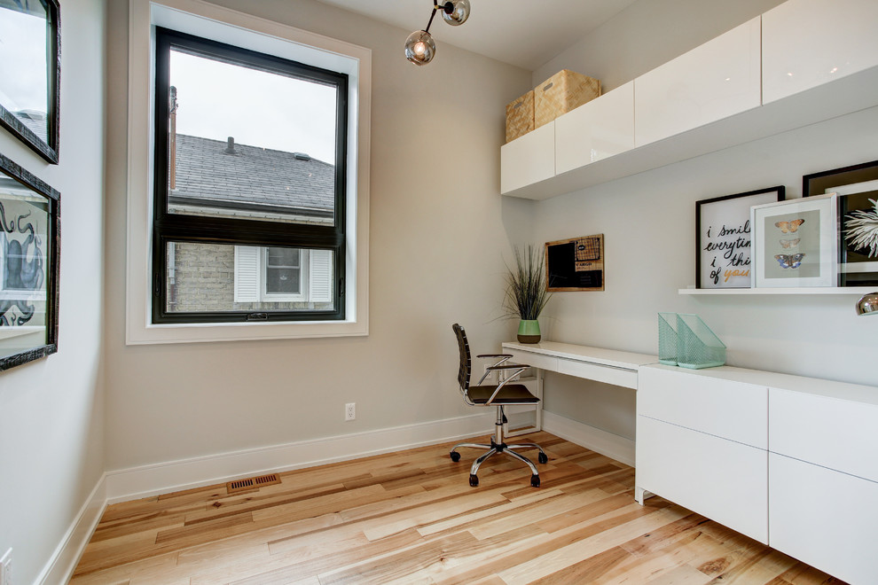 Mittelgroßes Modernes Arbeitszimmer ohne Kamin mit Arbeitsplatz, hellem Holzboden und freistehendem Schreibtisch in Toronto