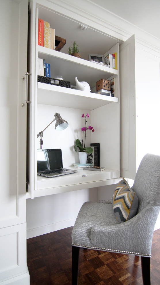 Photo of a small traditional study in Other with a built-in desk, white walls, dark hardwood flooring, no fireplace and brown floors.