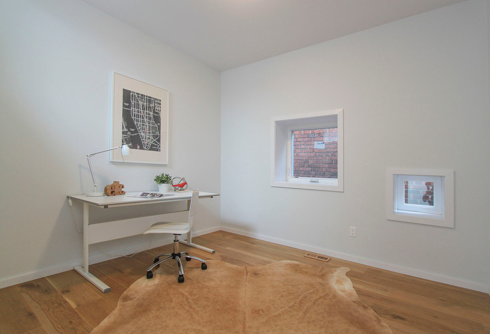 Idee per un piccolo atelier nordico con pareti bianche, parquet chiaro e scrivania autoportante