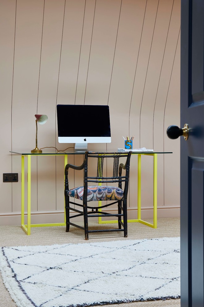 This is an example of an eclectic home office in London with beige walls, carpet, a freestanding desk and beige floors.