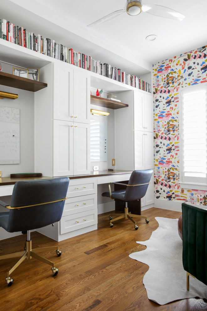 Foto de despacho bohemio de tamaño medio con paredes blancas, suelo de madera en tonos medios, escritorio empotrado, papel pintado y suelo marrón