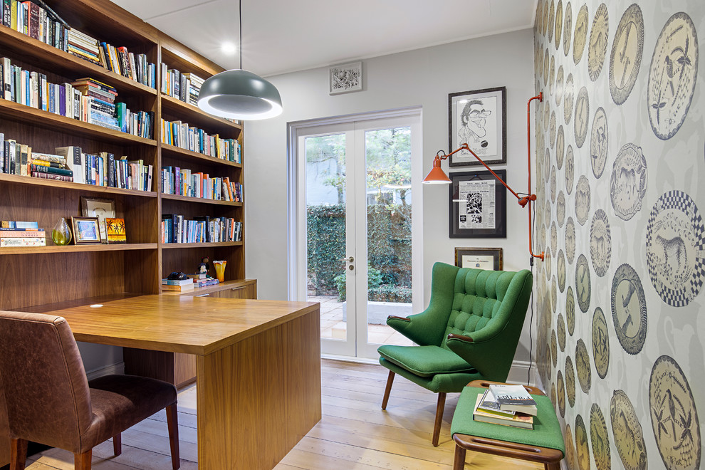Bild på ett eklektiskt hemmabibliotek, med grå väggar, ljust trägolv, ett inbyggt skrivbord och beiget golv