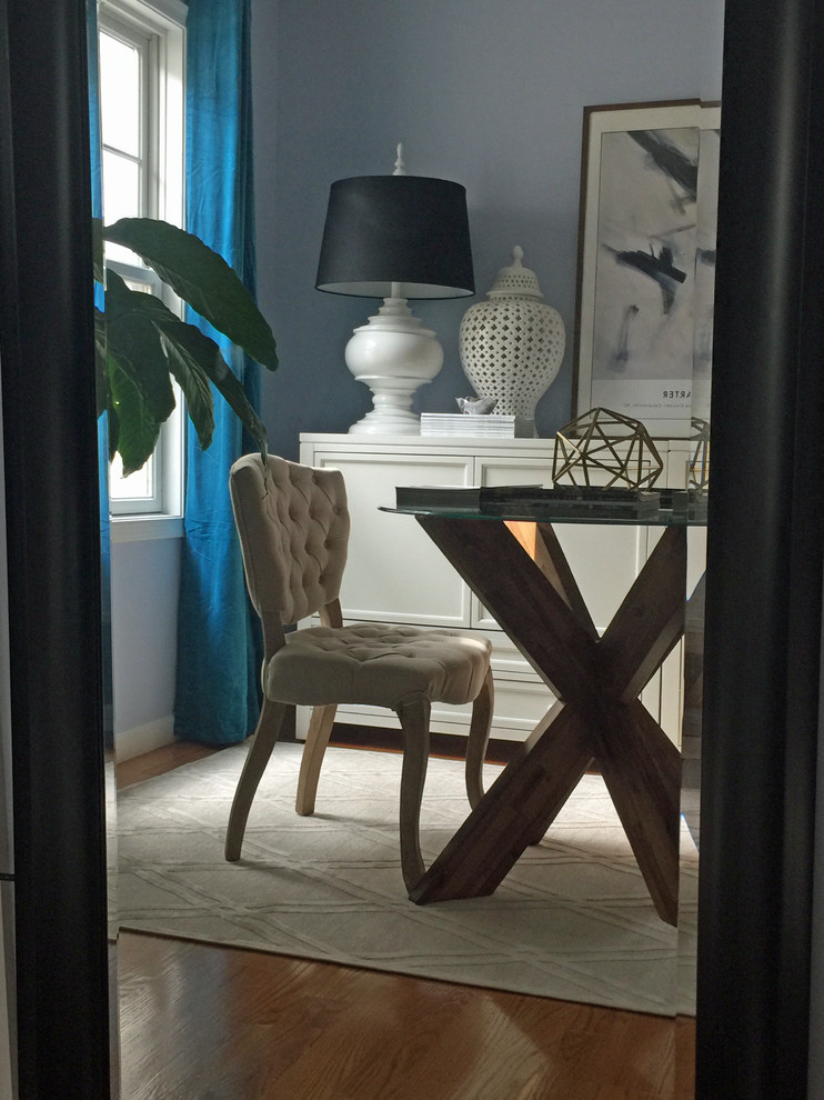 Small eclectic craft room in New York with blue walls, medium hardwood flooring, no fireplace, a freestanding desk and brown floors.