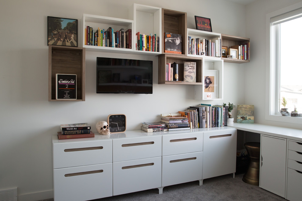 Idéer för mellanstora eklektiska hemmabibliotek, med vita väggar, heltäckningsmatta och ett fristående skrivbord