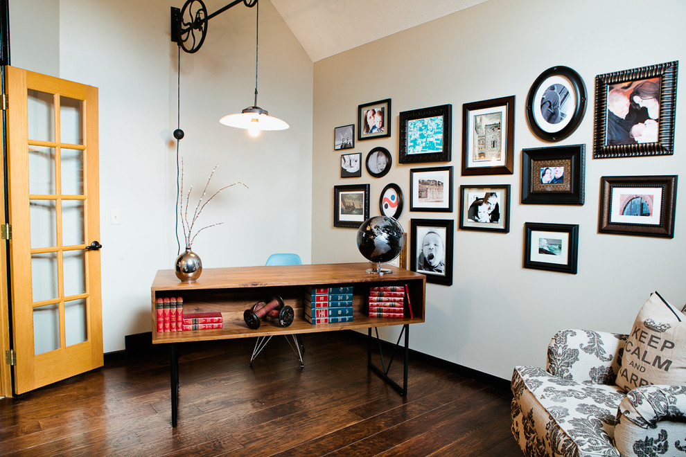 Mittelgroßes Stilmix Arbeitszimmer mit beiger Wandfarbe, dunklem Holzboden und freistehendem Schreibtisch in Omaha