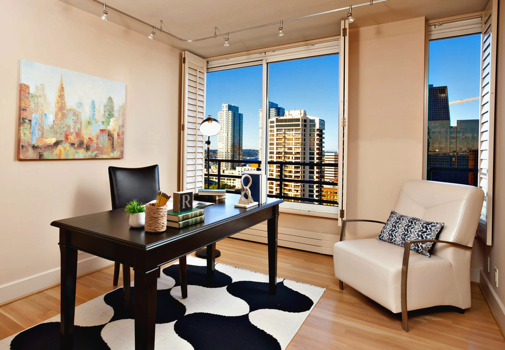 This is an example of a traditional home office in Seattle with beige walls, medium hardwood flooring, no fireplace and a freestanding desk.