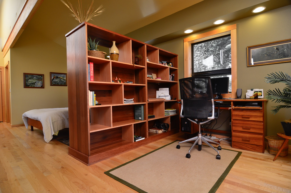 Bild på ett funkis arbetsrum, med gröna väggar, mellanmörkt trägolv och ett fristående skrivbord