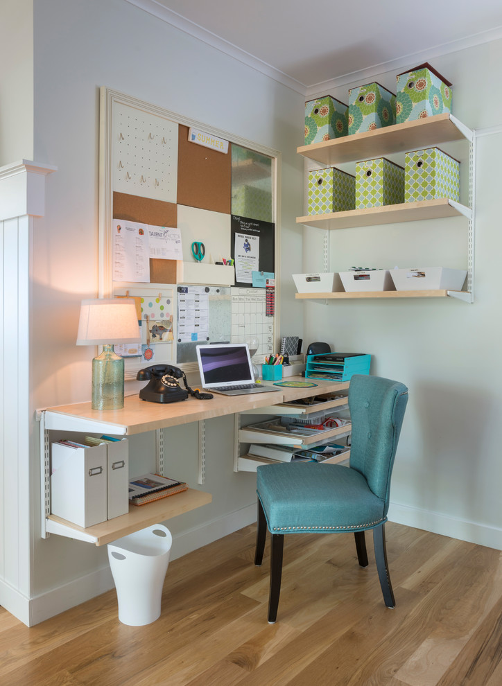Small cottage built-in desk medium tone wood floor home office photo in Providence with gray walls