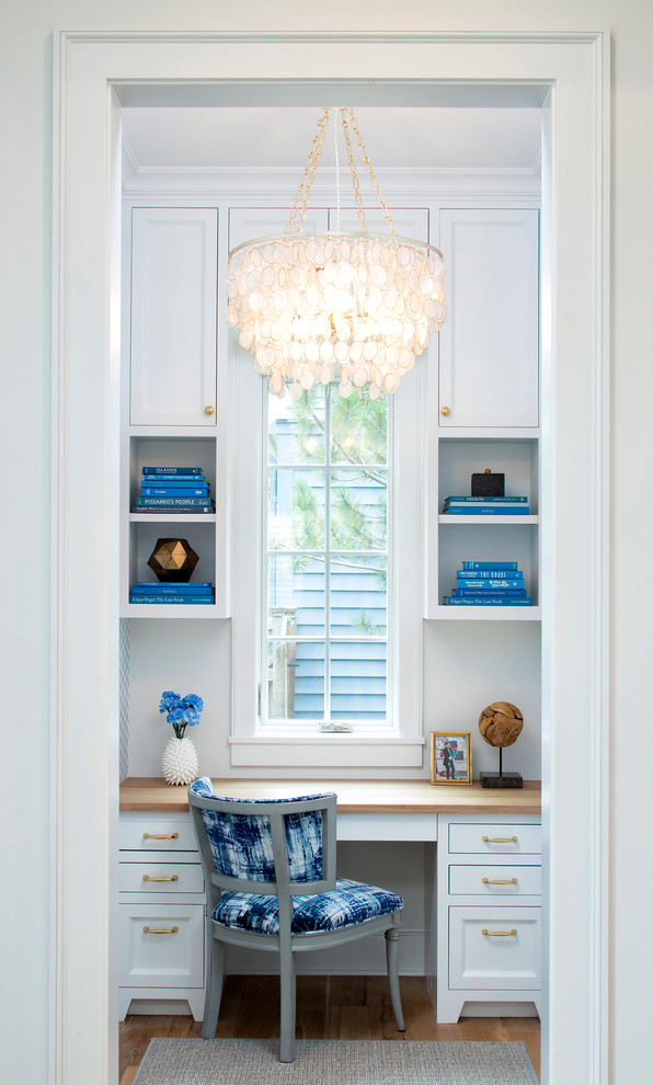 Inspiration for a small timeless built-in desk light wood floor study room remodel in Minneapolis with white walls