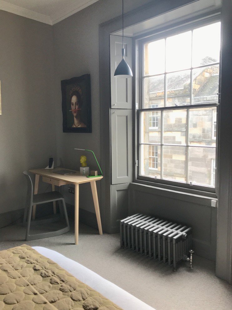 Foto på ett funkis arbetsrum, med grå väggar, heltäckningsmatta, en standard öppen spis, en spiselkrans i sten, ett fristående skrivbord och grått golv