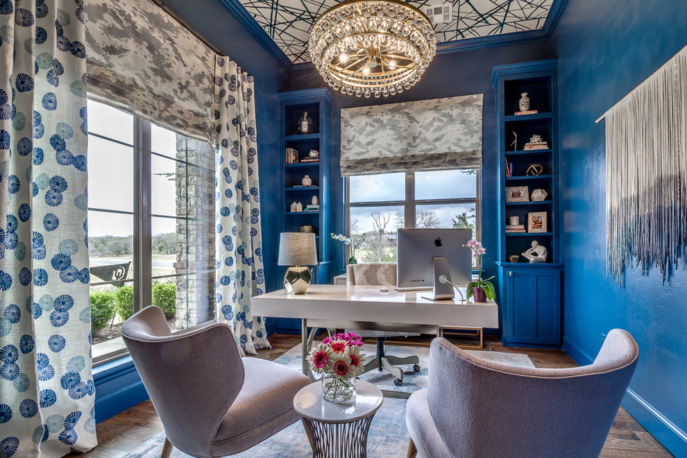 На фото: кабинет среднего размера в стиле неоклассика (современная классика) с синими стенами, темным паркетным полом, отдельно стоящим рабочим столом и коричневым полом без камина с