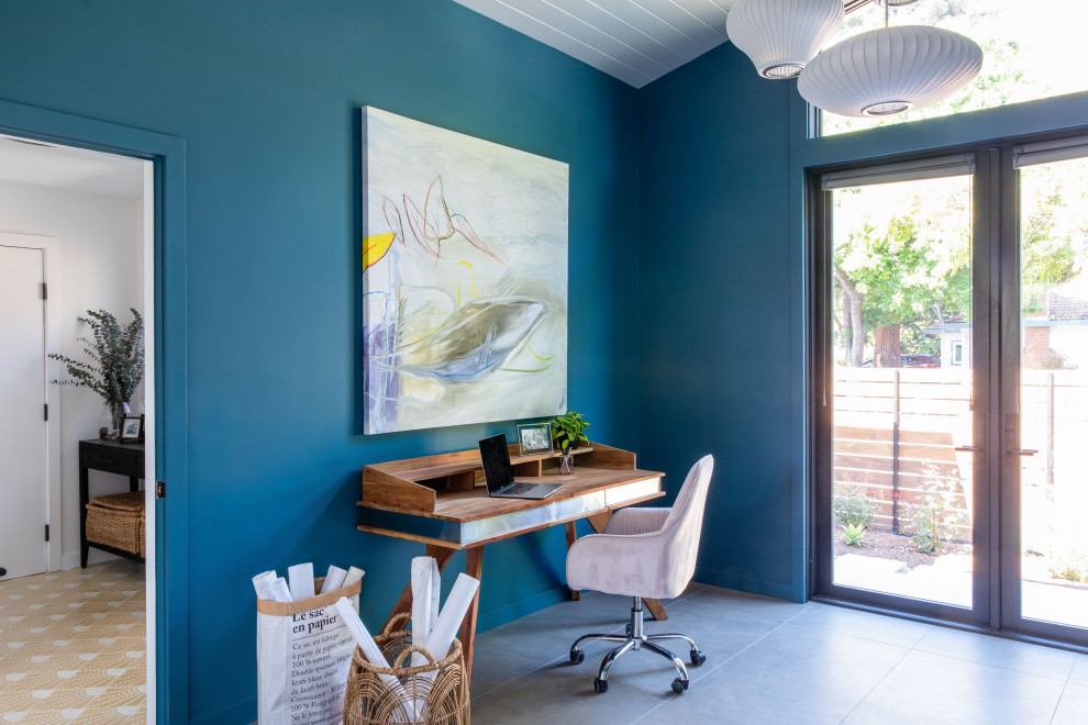 Großes Mid-Century Arbeitszimmer mit Arbeitsplatz, blauer Wandfarbe, Porzellan-Bodenfliesen, freistehendem Schreibtisch, grauem Boden und Holzdielendecke in San Francisco