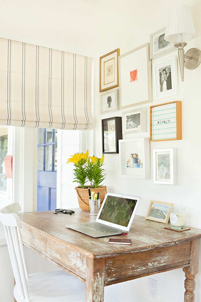 Immagine di un piccolo ufficio stile marinaro con pareti bianche e scrivania autoportante