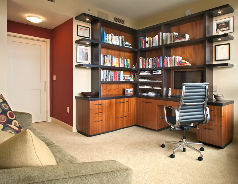Foto på ett mellanstort funkis hemmabibliotek, med beige väggar, heltäckningsmatta, ett inbyggt skrivbord och beiget golv