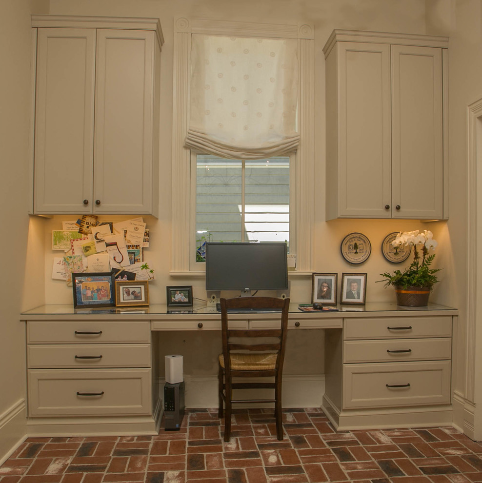 Foto de despacho tradicional de tamaño medio con suelo de ladrillo y escritorio empotrado