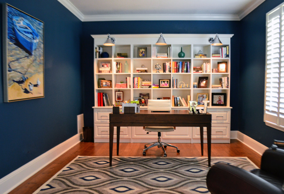 Idéer för små maritima arbetsrum, med ett bibliotek, blå väggar, mellanmörkt trägolv, ett fristående skrivbord och brunt golv